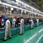 Employees work on an assembly line of Honda Motorcycle & Scooter India during a media tour to the newly inaugurated plant at Vithalapur